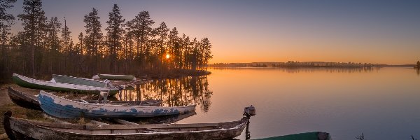 Drzewa, jezioro Pallasjärvi, Zachód słońca, Łódki, Park Narodowy Pallas-Yllästunturi, Finlandia