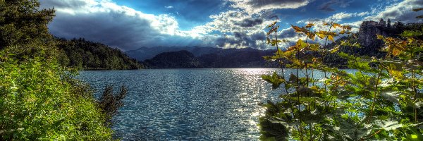 Promienie słońca, Jezioro Bled, Zamek Bled, Skały, Drzewa, Góry, Alpy Julijskie, Słowenia