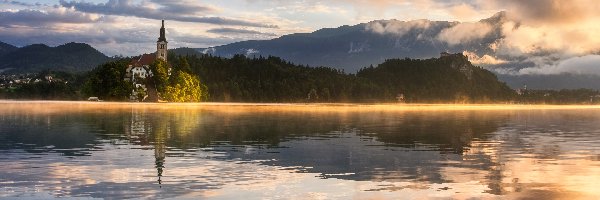 Mgła, Kościół, Drzewa, Wschód słońca, Góry Alpy Julijskie, Jezioro Bled, Las, Słowenia, Wyspa Blejski Otok, Chmury