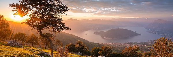 Drzewa, Włochy, Domy, Lake Iseo, Chmury, Góry, Dolina Val Camonica, Mgła, Alpy Lombardzkie, Jezioro, Wschód słońca